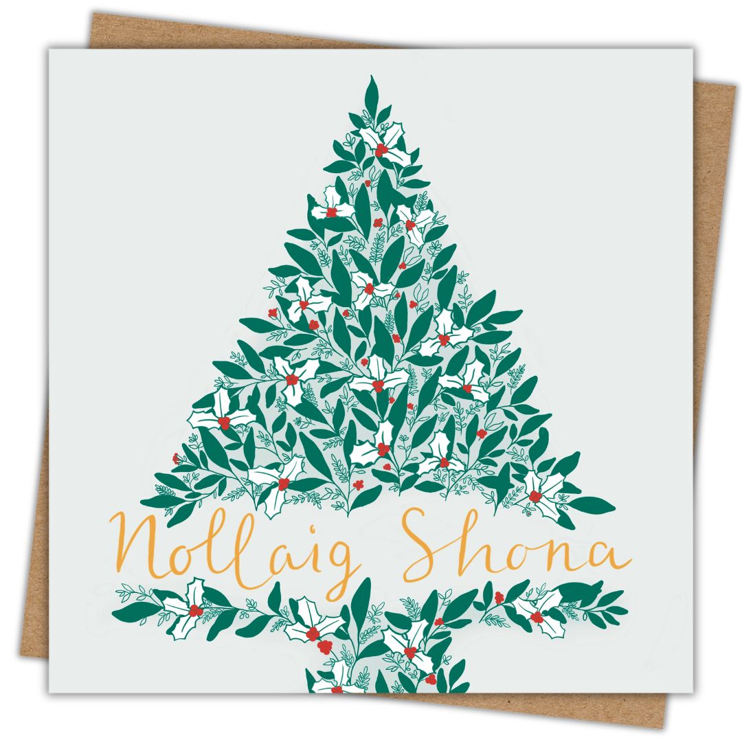 Christmas card with the words Nollaig Shona written along the bottom of an illustration of a Christmas tree. The writing is in gold. The tree is a mixture of larger green leaves, white holly leaves, red berries and smaller intricate foliage. The background of the card is a very soft light grey/green. The card has an accompanying recycled Kraft brown envelope which is just visible behind it.
