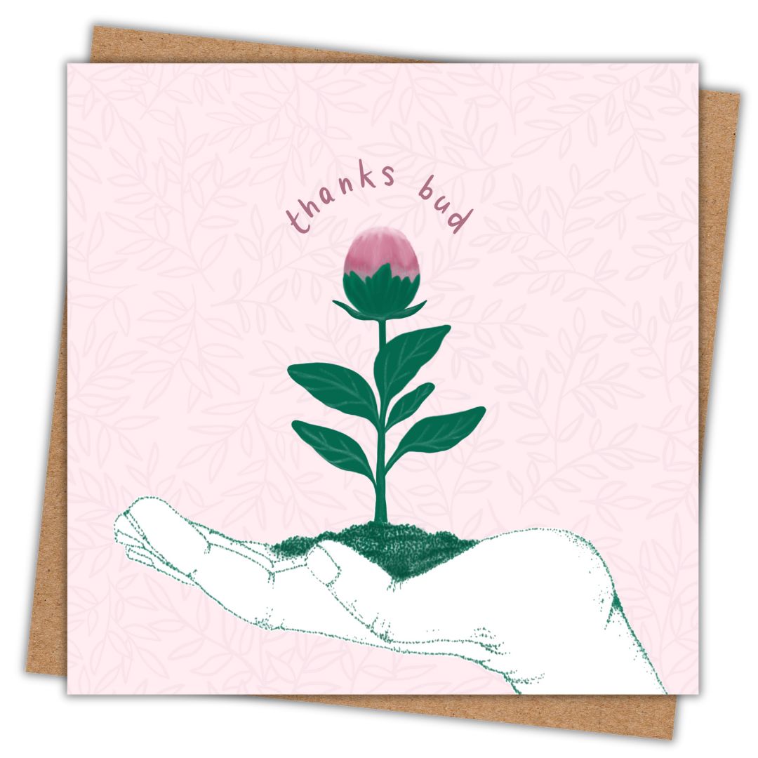 Irish Botanical note card "thanks bud" with a soft pink background. The image on the card is the outline of an open hand facing upward. Growing out of the palm of the hand is a small seedling in dark green with a plump pink bud at the top. Surrounding the top of the bud are the words "thanks bud" in a dusky pink hand writing. There is a brown Kraft envelope sitting in behind the card.