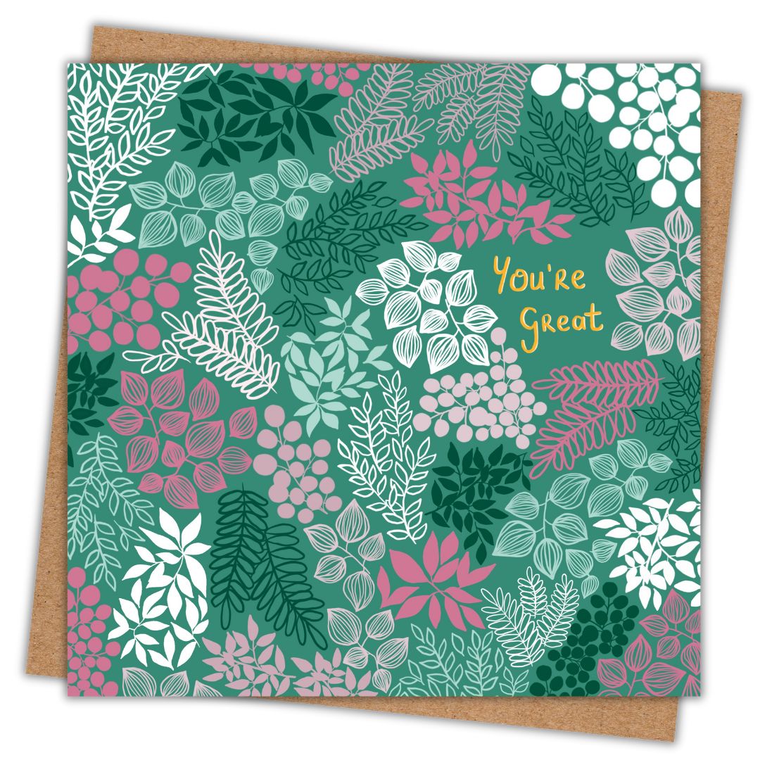 Simple image of a greeting card with its brown Kraft envelope behind it. The card is a deep green with the words "You're Great" written in gold lettering to the top right of the card. Surrounding the writing are lots of clusters of leaves and floral details in various shades of green, white, and pink.