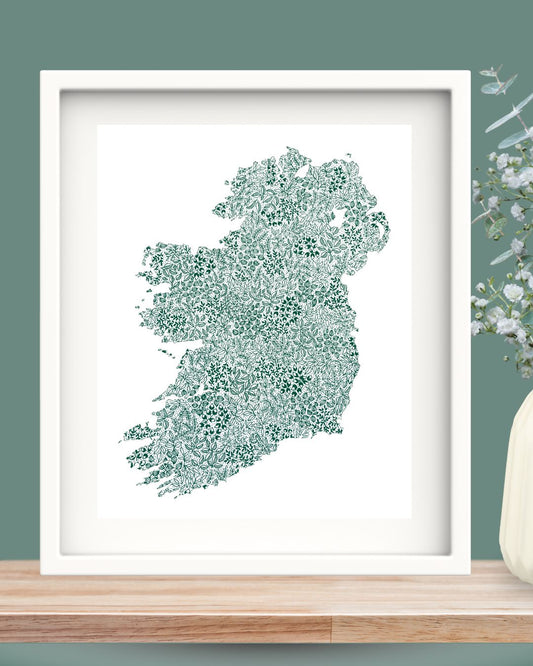 Framed 10x12 Ireland print featuring intricate botanical details in green, styled on wooden surface with vase and flowers nearby