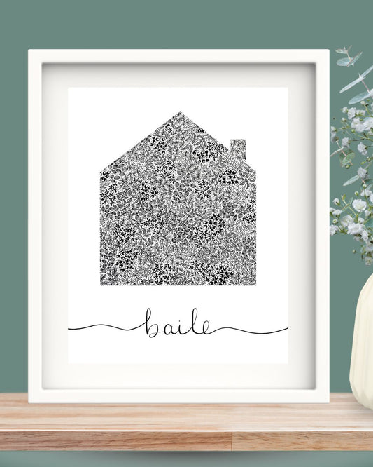 Black and white floral pattern shaped like a house with handwritten "baile" below in a white 10x12 frame styled on wood