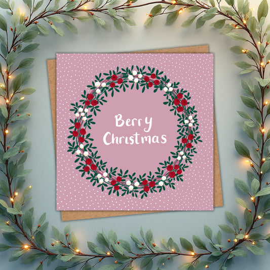 Christmas card in a berry pink, which says Berry Christmas in white in the centre of a wreath.