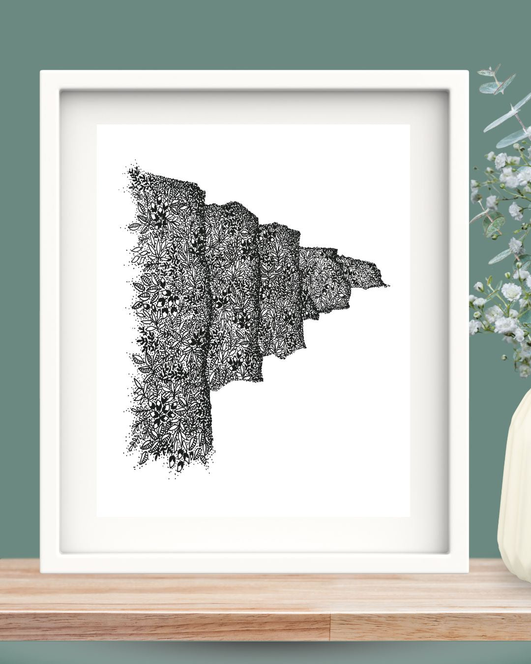 Pen illustration of the Cliffs of Moher in an intricately detailed style. The cliffs are drawn with leaves and dots only, while still retaining the structure and depth of the cliffs. Framed in a white solid wood Irish frame.