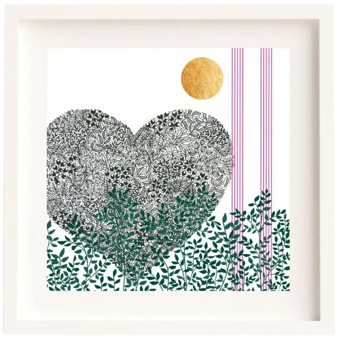 Image of a framed botanical art print featuring a black pen heart illustration. The heart is composed of detailed black leaf patterns, with green leafy foliage running along the base of the print. A gold leaf sun is positioned in the top right corner, alongside thin vertical bright pink lines. The artwork is set against a white background and framed in a clean, white wooden frame and a white mount.