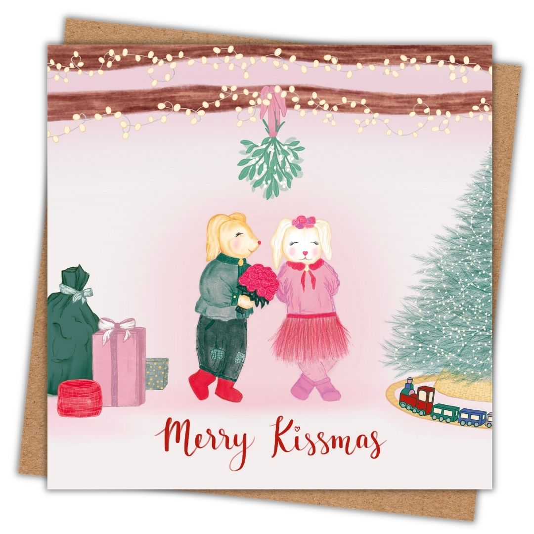 A sweet romantic Christmas card in soft colours with two little animals under the mistletoe. The male is holding a bouquet of pink roses and the female is smiling. Underneath this sweet little Christmas scene are the words "Merry Kissmas"