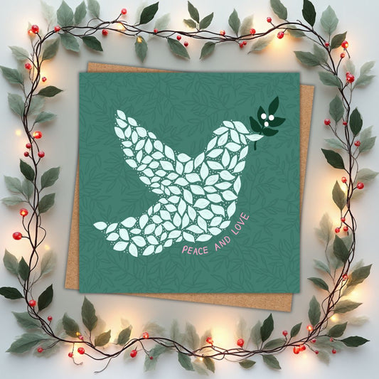 Christmas Card with a dove design made of leaf shapes and the words 'Peace and Love' in a soft pink font underneath. The card is surrounded by decorative leaves and lights.
