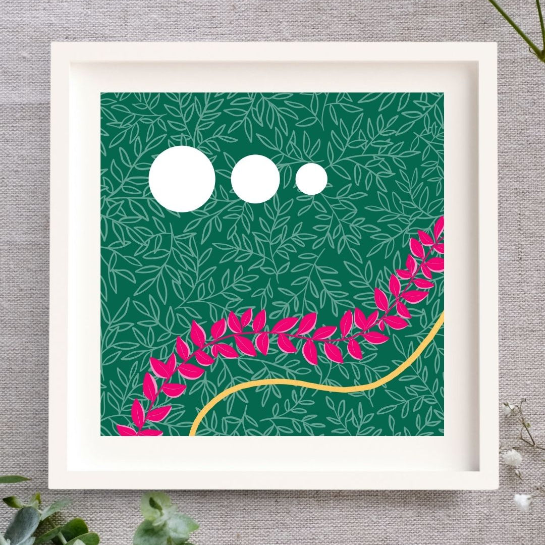 Framed artwork of a leafy illustration. There's a dark green background with a layer of light green leaf outlines on top. There are three white circles in the top half, to the left ranging from big to small, left to right. In the bottom half there is a wave of bright pink leaves passing though the print, and below that following the same curve is a wave of gold created by gold leaf. The print is in a white mount, white wooden frame set on a natural cloth background with foliage around it.